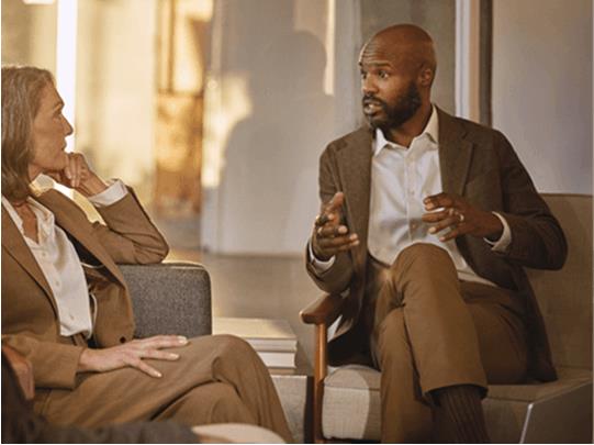 side view of woman seated on couch meeting with a financial advisor